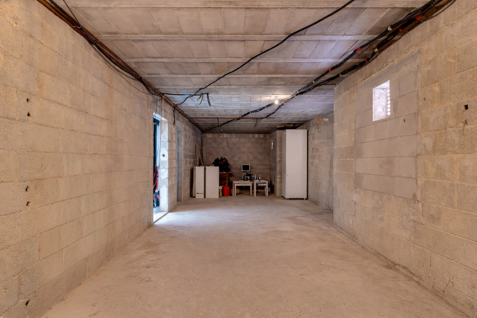 Ruime onafgewerkte ruimte met betonnen muren en hoge plafonds, die volop mogelijkheden biedt voor de uitbreiding van extra kamers of een zelfstandig appartement.