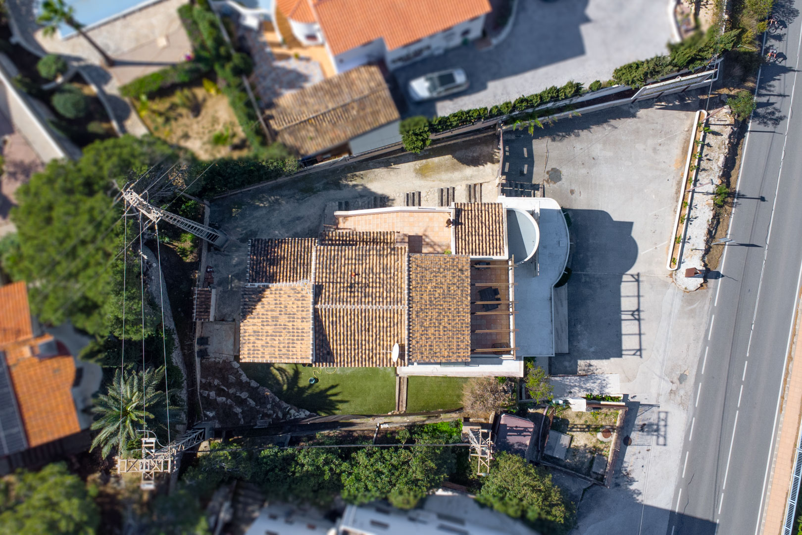 Bovenaanzicht vanuit de lucht met de indeling van het pand, de pannendaken, de buitenterrassen en de ruime parkeergelegenheid direct aan de hoofdweg.