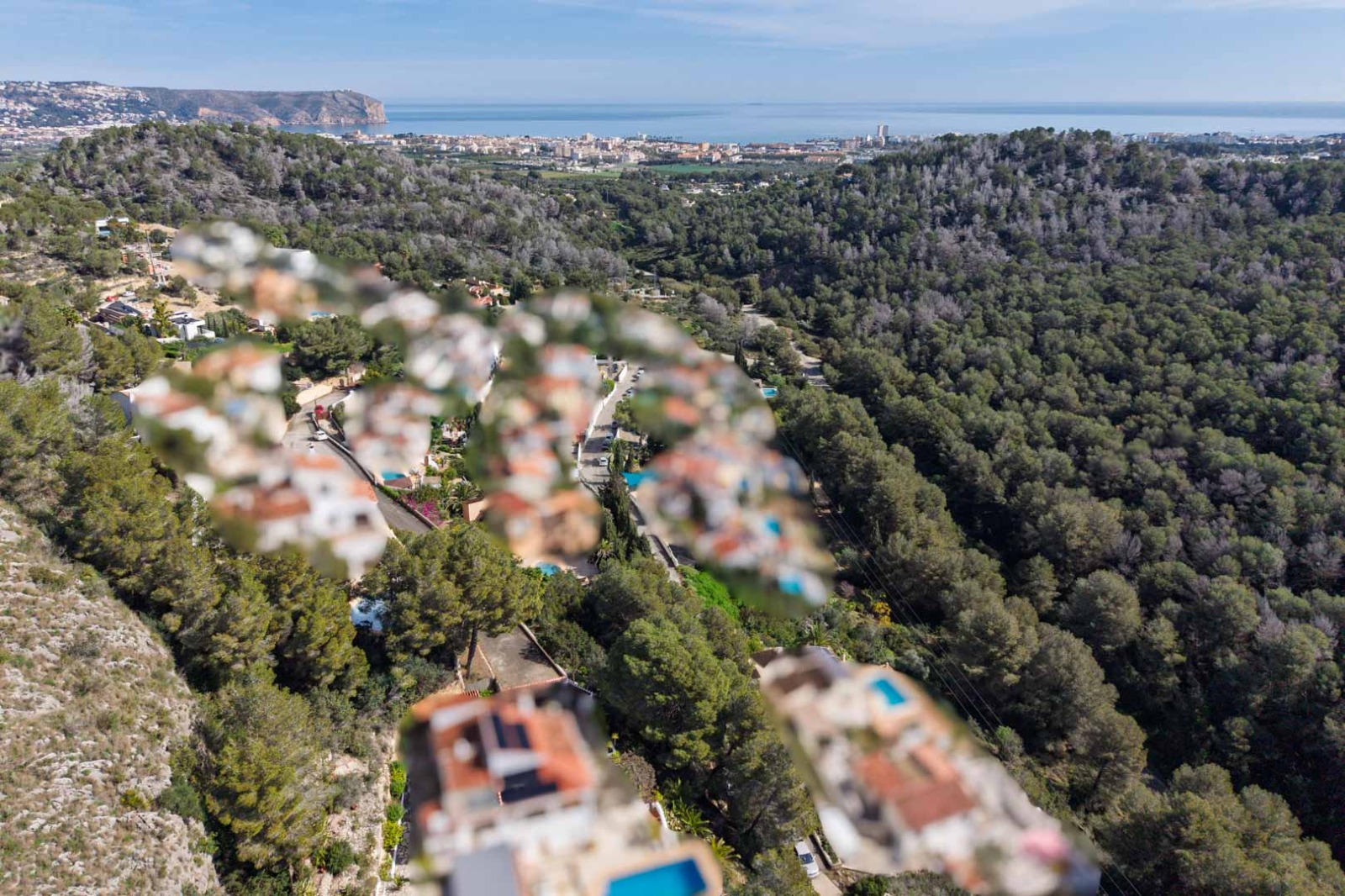 Panoramisch luchtfoto vanaf Sol de Este over beboste heuvels met een weids uitzicht op de kustlijn van Jávea en de Middellandse Zee.