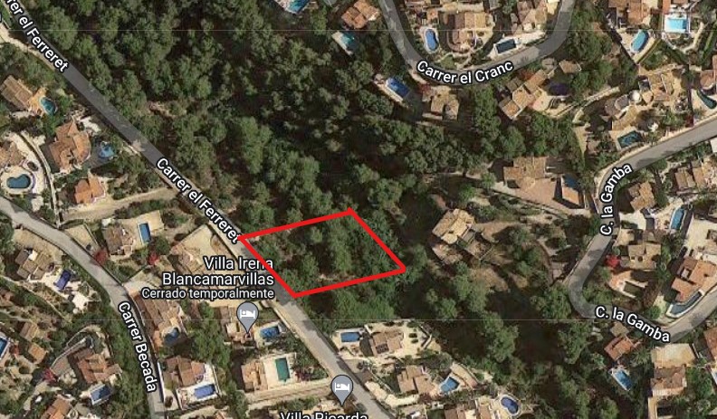 Satelliet-luchtfoto van het rood omlijnde perceel van 826 m2 aan de Carrer el Ferreret, gelegen in een bosrijke woonwijk nabij bestaande villa's.