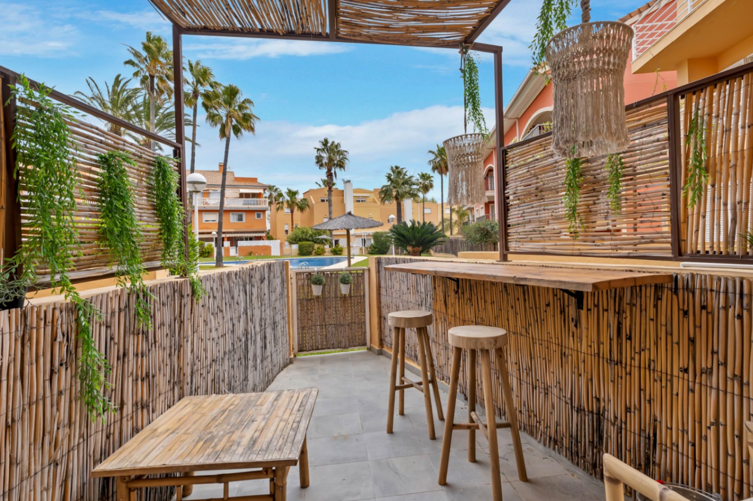Privé terras met bamboe bar, uitzicht op het gemeenschappelijk zwembad en de tuinen.