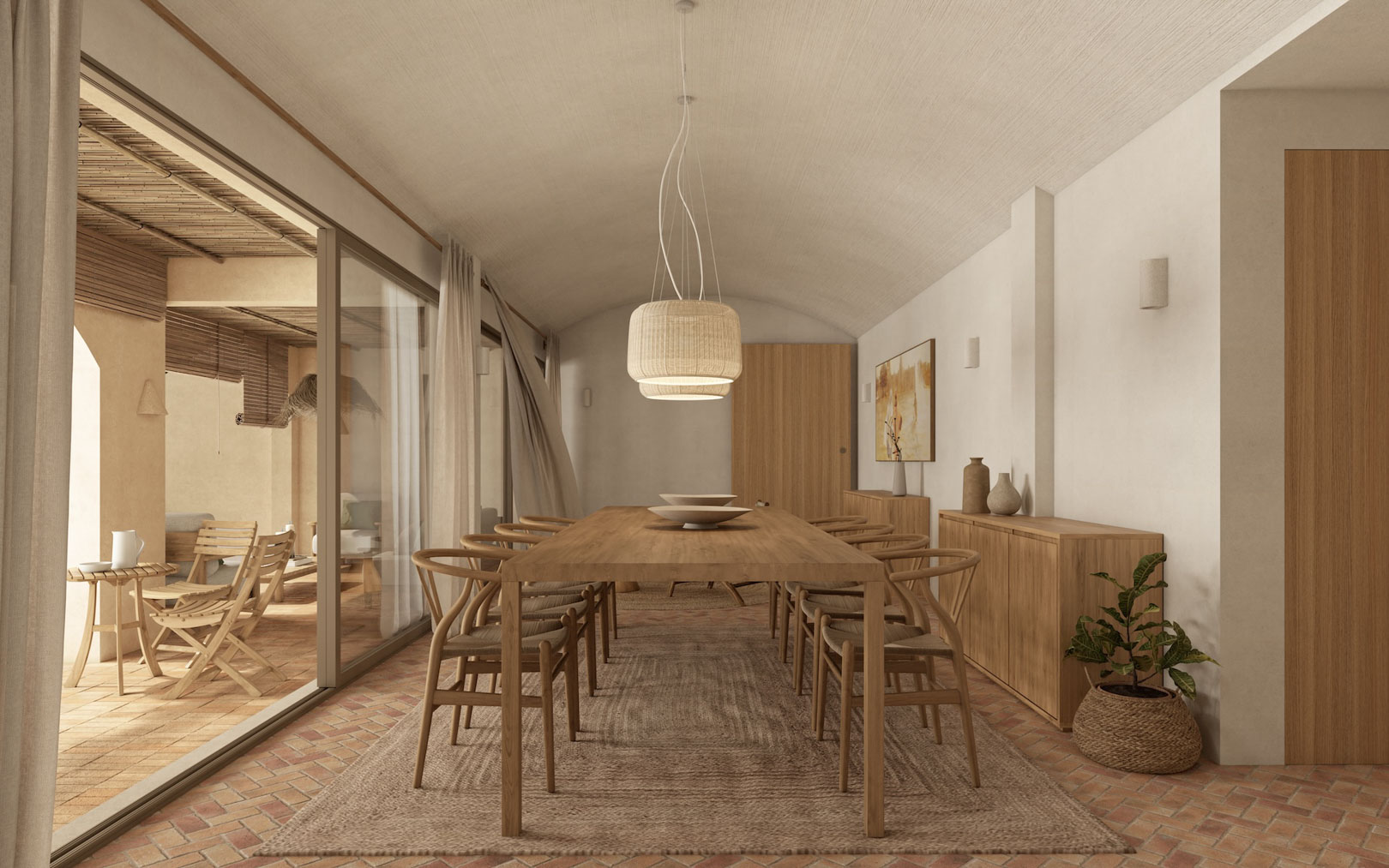 Eetkamer met gewelfd plafond, houten tafel en Wishbone-stoelen op een terracotta vloer. Grote schuifdeuren bieden directe toegang tot het overdekte mediterrane terras.
