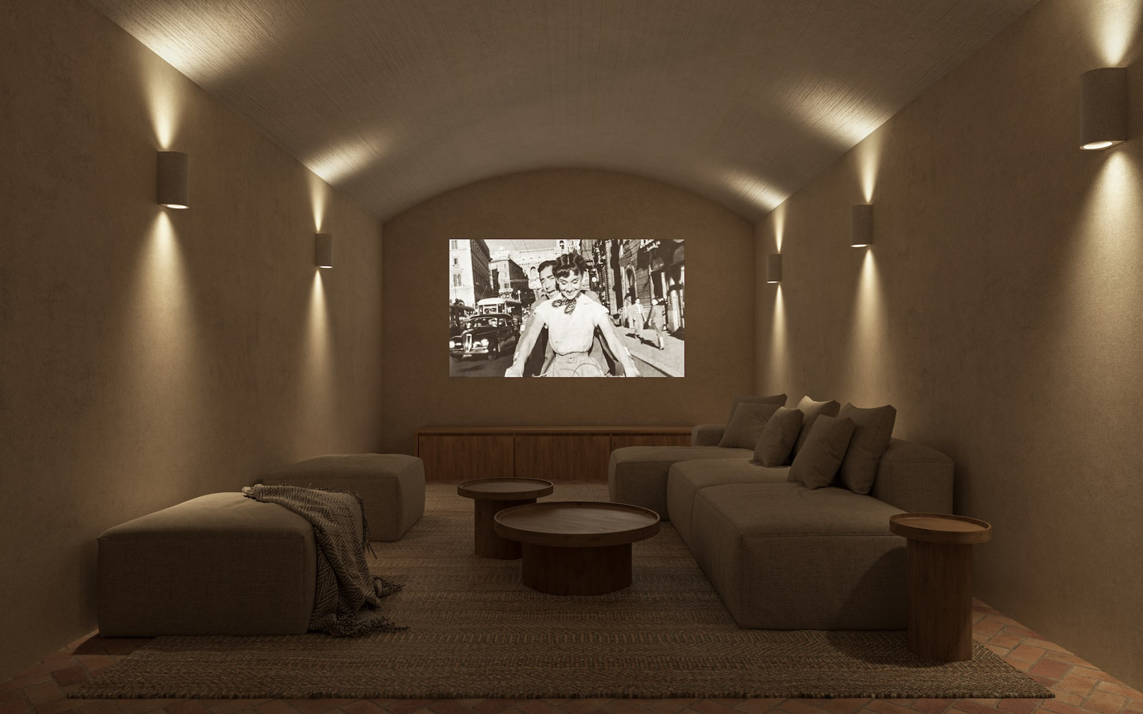 Privé bioscoopruimte met een gewelfd plafond, gestructureerde muren en warme wandverlichting. Voorzien van modulaire banken, houten tafels en een traditionele terracotta vloer.