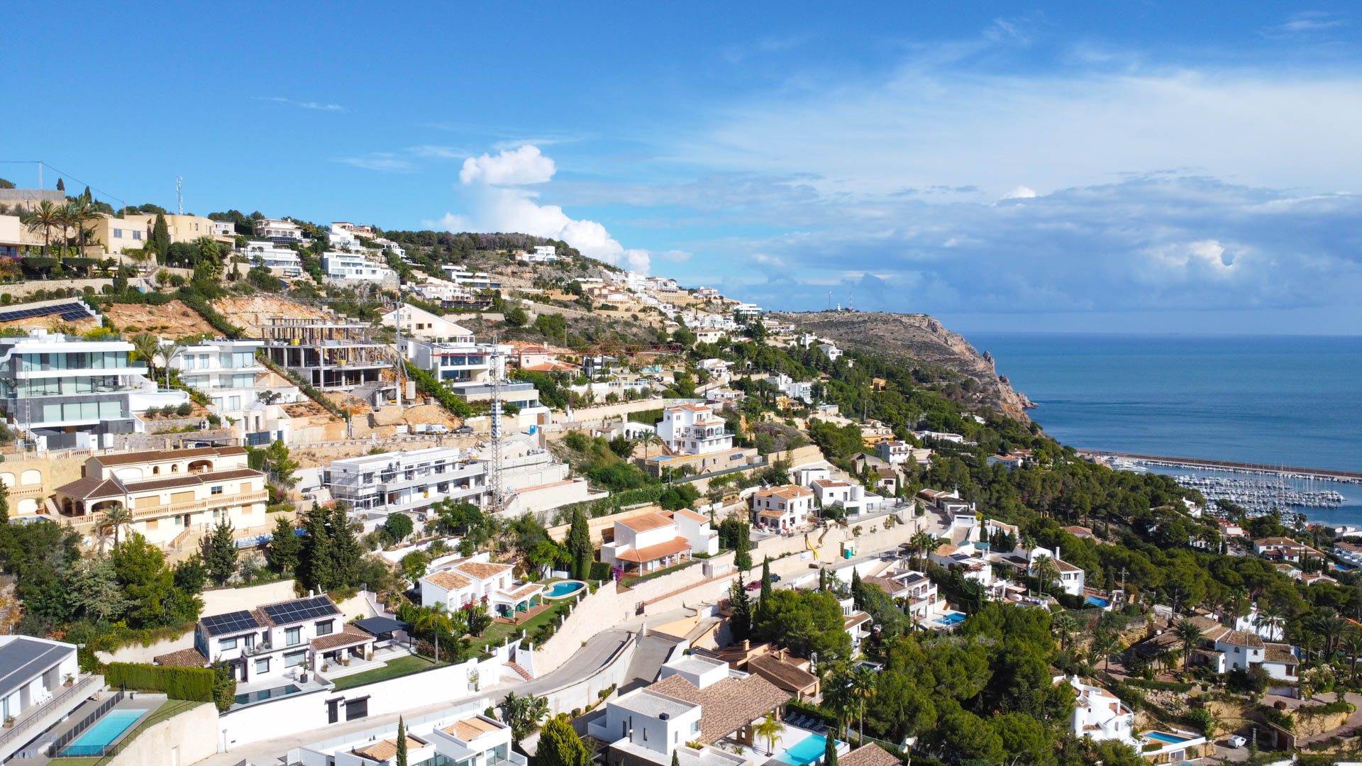 Luchtfoto van de woonwijk La Corona in Jávea, met de ligging op de heuvel en het weidse uitzicht over de Middellandse Zee en de haven.