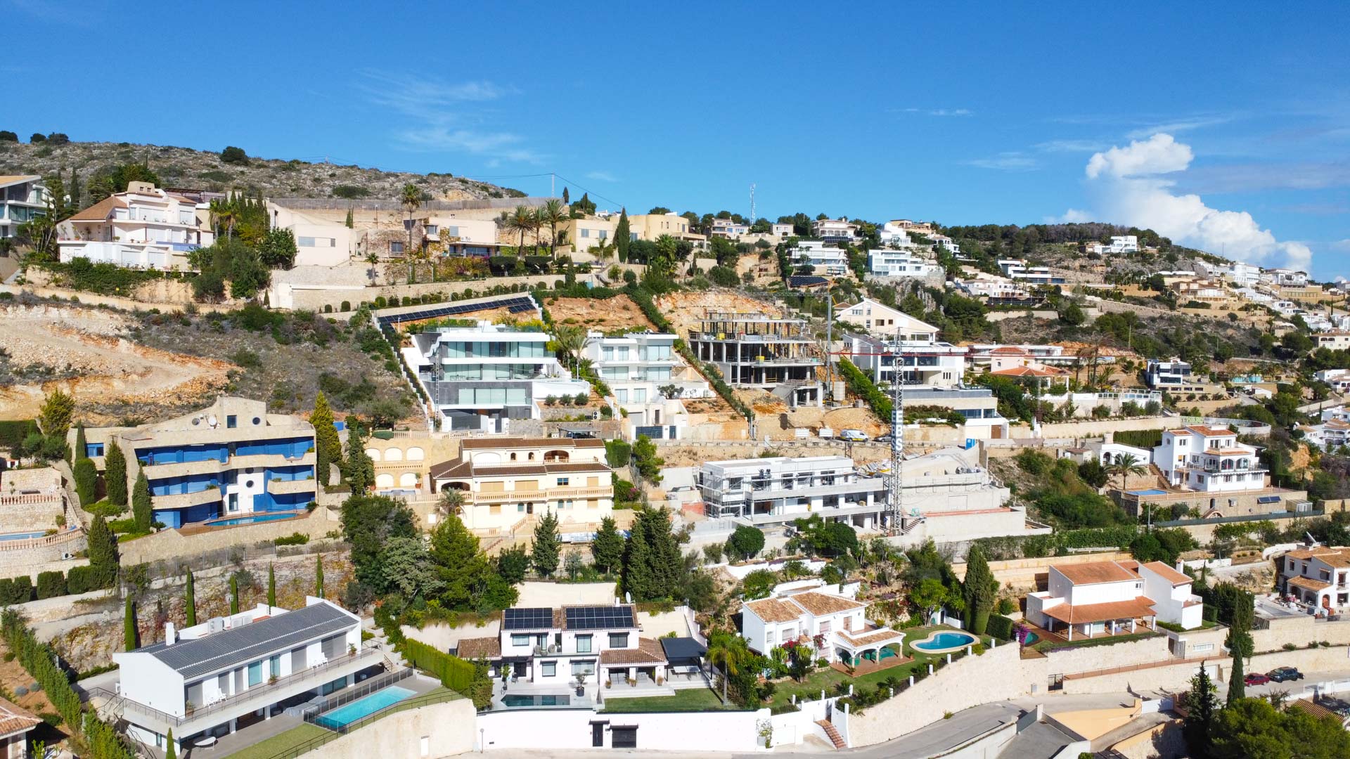 Luchtfoto van de woonwijk La Corona in Jávea, met de terrasvormige ligging van de villa's op de heuvel en het uitzicht over de kustlijn.