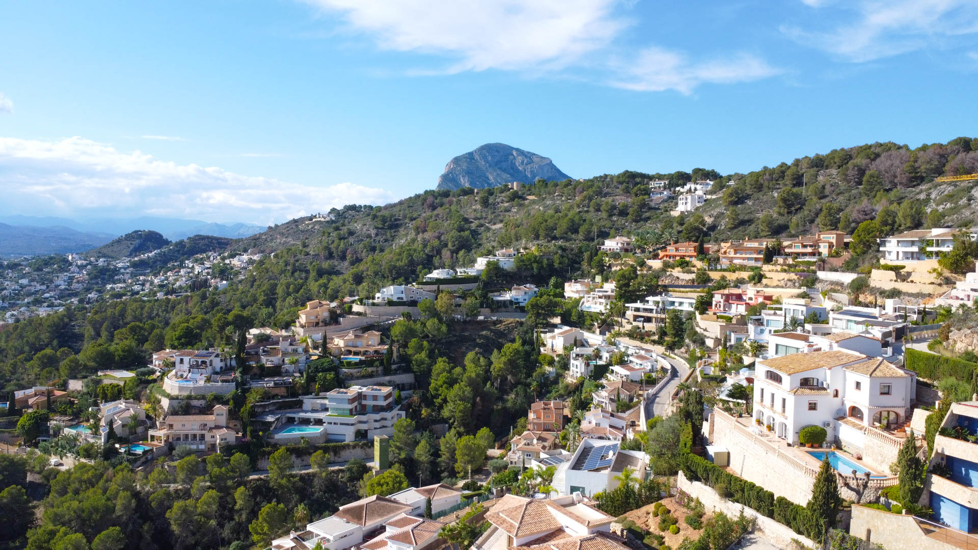 Luchtfoto van de woonwijk La Corona in Jávea, met mediterrane villa's op de heuvelrug en de berg Montgó op de achtergrond.