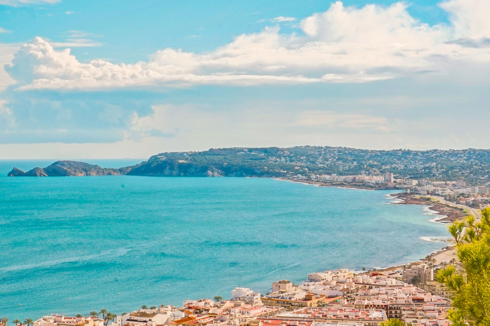 Panoramisch uitzicht over de baai van Jávea vanuit La Corona, met de kustarchitectuur en de landtong Cap Negre aan de azuurblauwe Middellandse Zee.