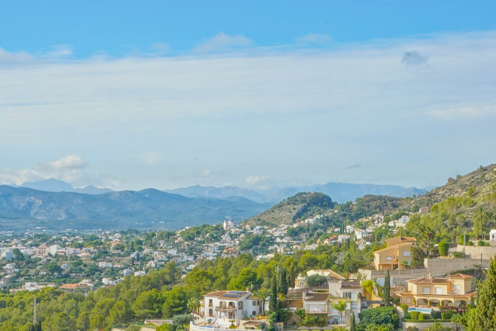 Panoramisch uitzicht vanaf het pand over de vallei en de omliggende bergketens, met de mediterrane begroeiing en het residentiële landschap van Jávea.