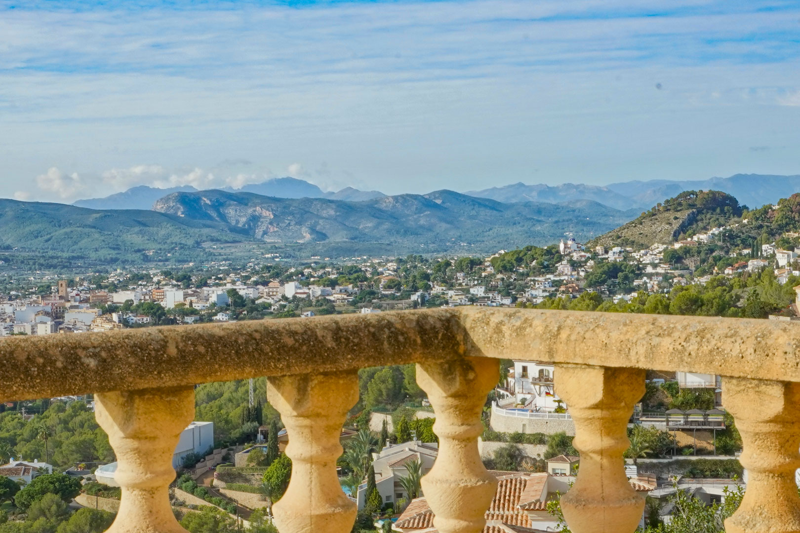 Panoramisch uitzicht vanaf het terras met traditionele stenen balustrade over de vallei van Jávea en de omliggende bergketens.