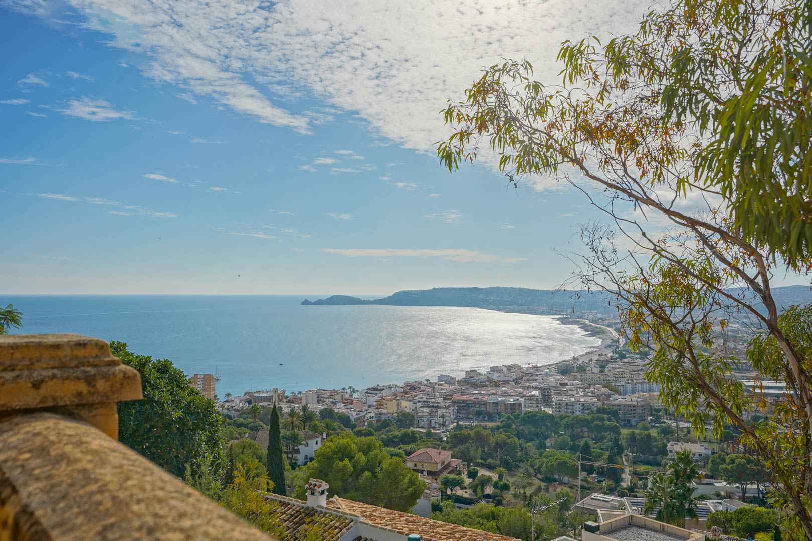 Panoramisch uitzicht vanaf het terras over de baai van Jávea en Cap Negre, met zicht op de haven en de Middellandse Zee onder een heldere hemel.