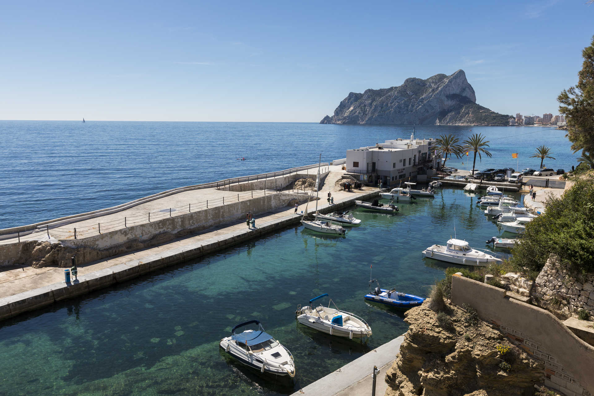 Panoramisch uitzicht op de nabijgelegen jachthaven met de Peñón de Ifach op de achtergrond, wat de kristalheldere wateren en de nabijheid van de villa tot de Middellandse Zee benadrukt.