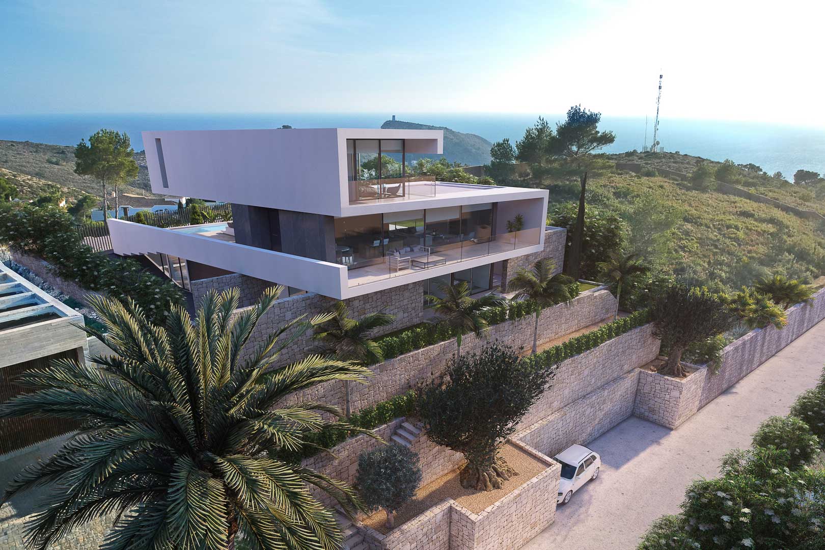 Buitenaanzicht van de moderne villa met stenen muren, terrassen met glazen balustrades en uitzicht op zee.