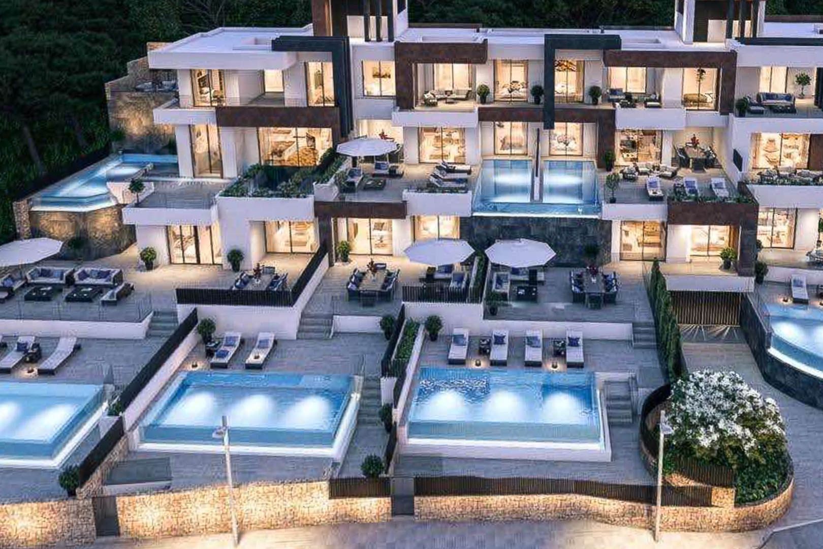 Exterieur van een modern wooncomplex met trapsgewijze terrassen, verlichte privézwembaden en gevels van natuursteen en witte afwerkingen.