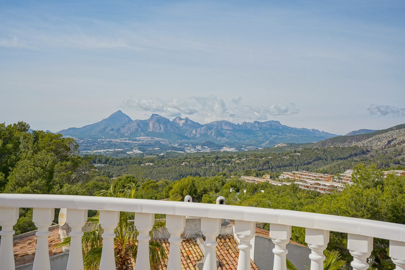 Terras met klassieke witte balustrade en panoramisch uitzicht over de bergketens van de Puig Campana en Sierra Aitana.