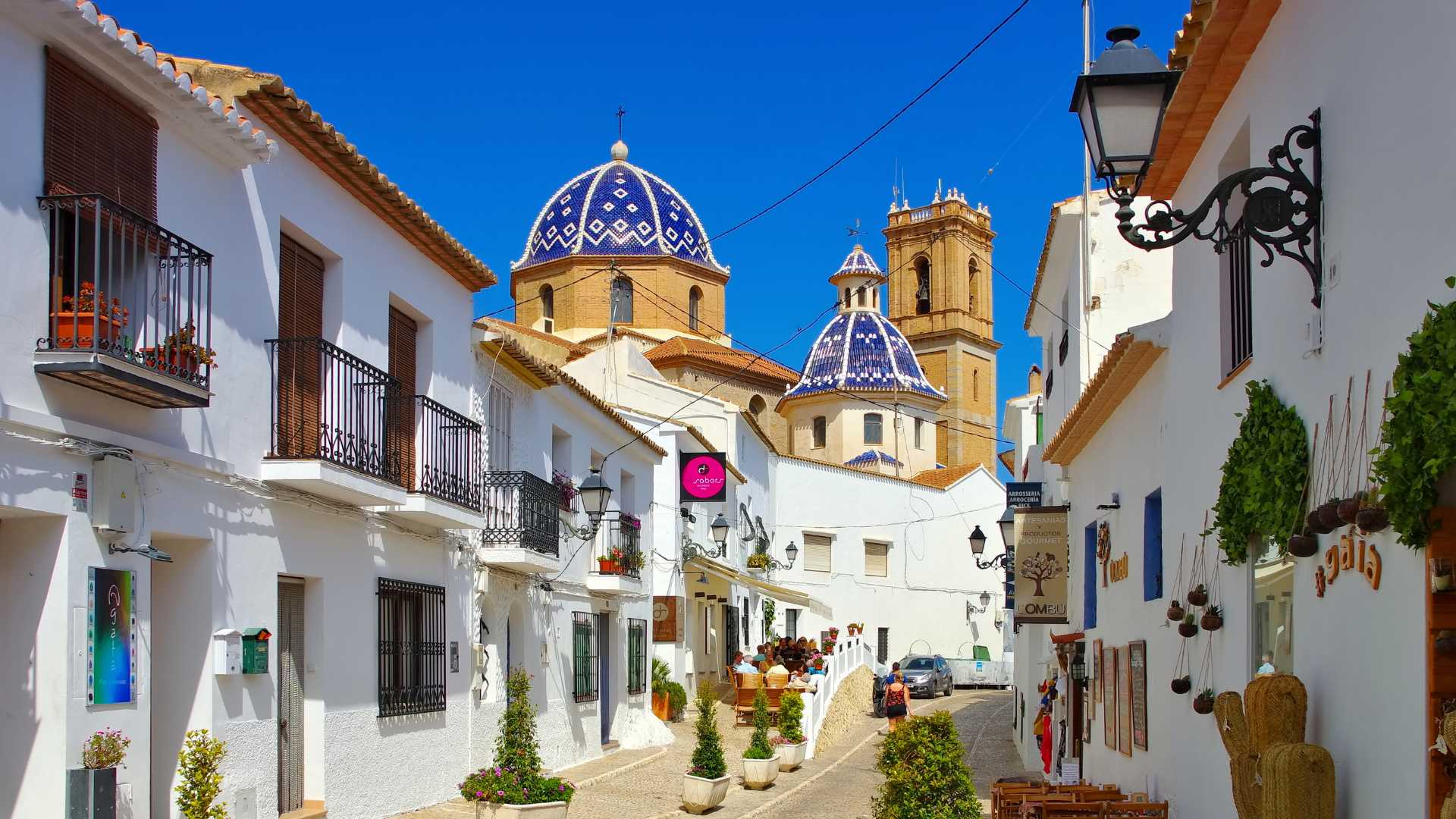 Uitzicht op de oude stad van Altea met smalle kasseienstraatjes, witgekalkte huizen en de iconische blauw-wit betegelde koepels van de kerk onder een heldere hemel.