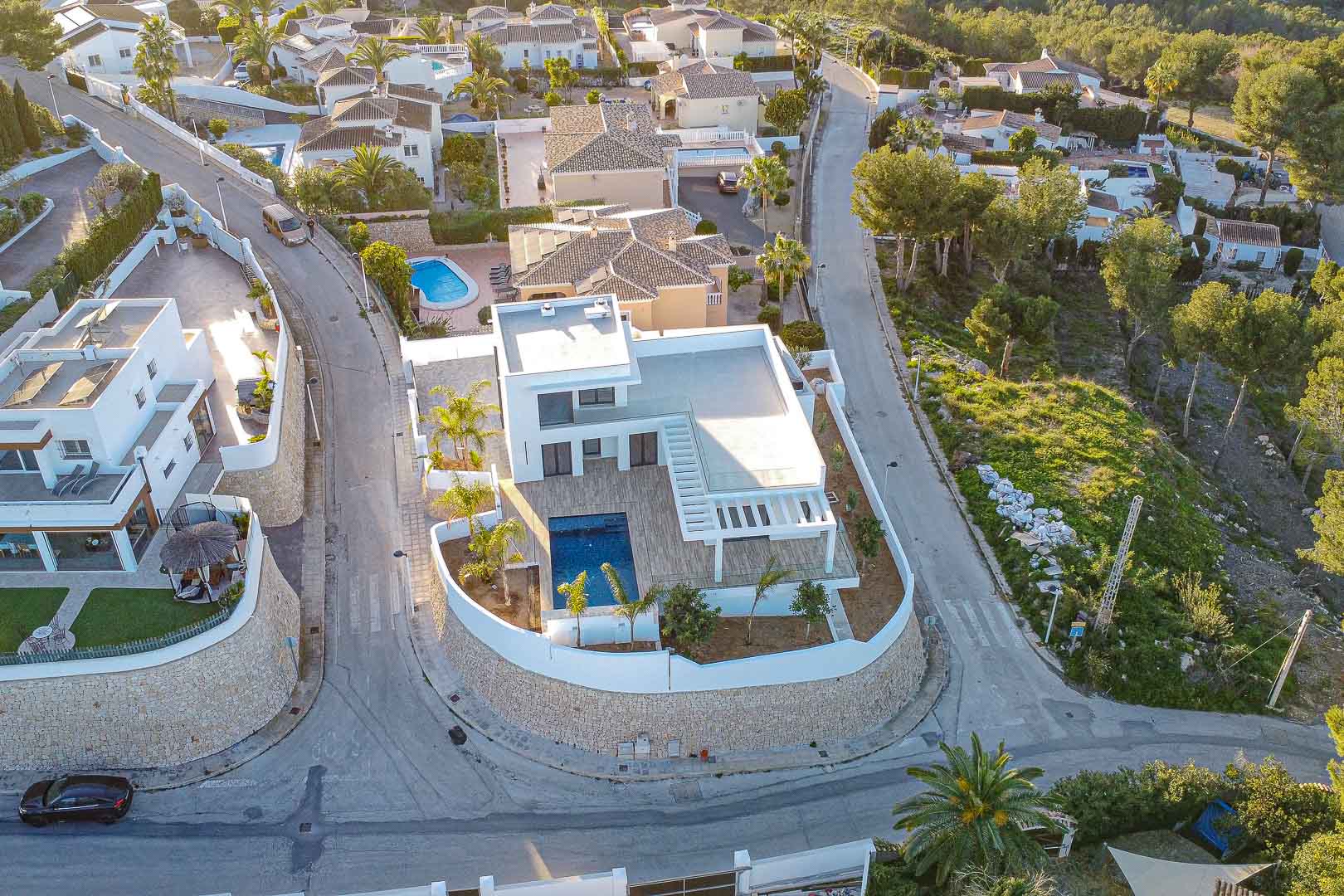 Luchtfoto van moderne villa met zwembad in Benimeit, Moraira. Minimalistisch design, terrassen en mediterrane tuin.