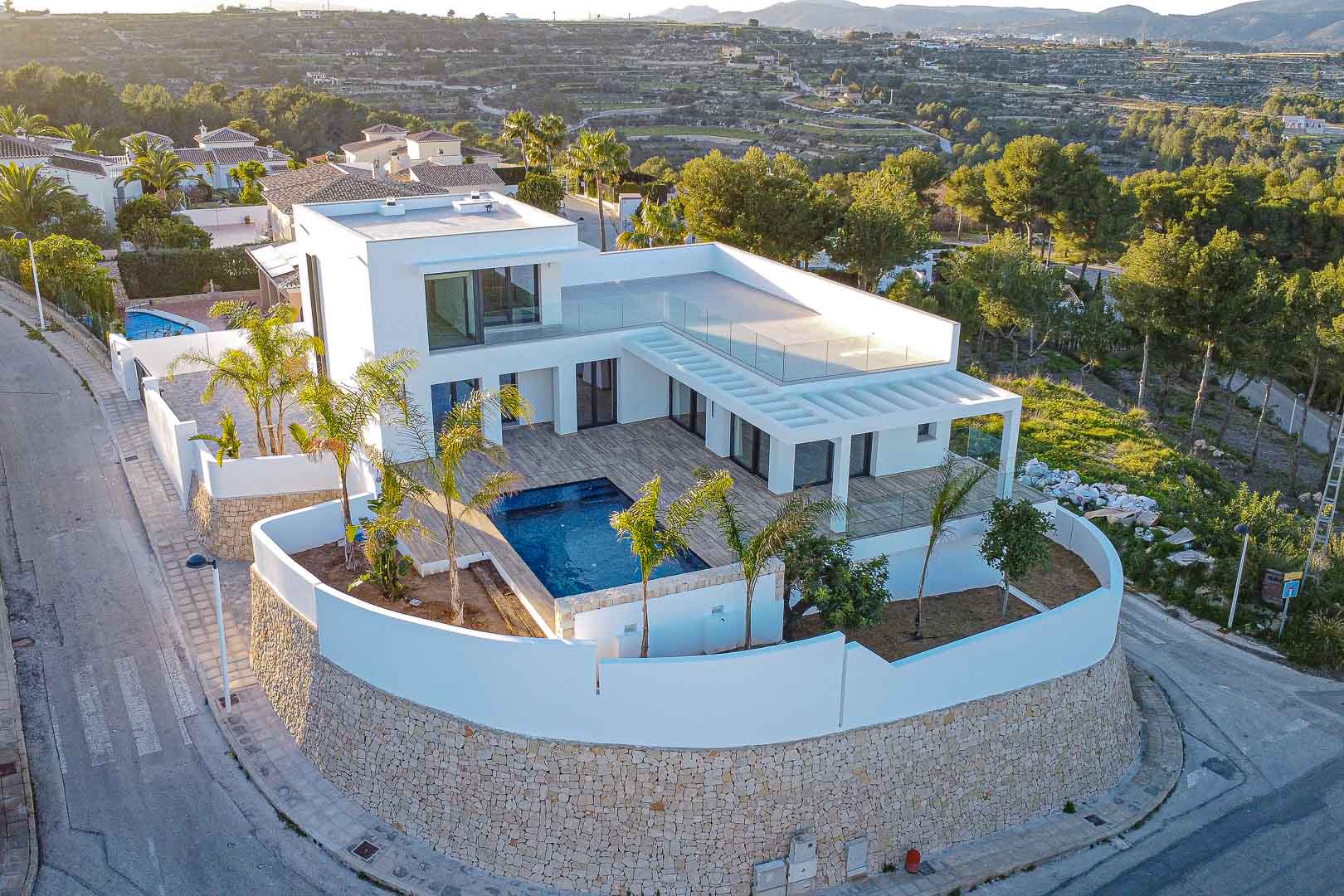 Luchtfoto van moderne villa met zwembad, terrassen en mediterrane tuin in Benimeit, Moraira.