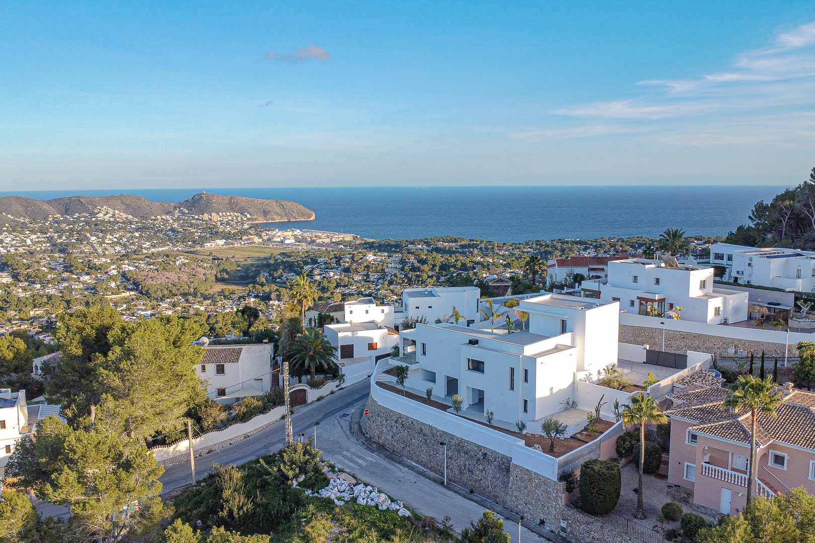 Luchtfoto van moderne witte villa in Benimeit met panoramisch uitzicht op de zee en het stadsbeeld.
