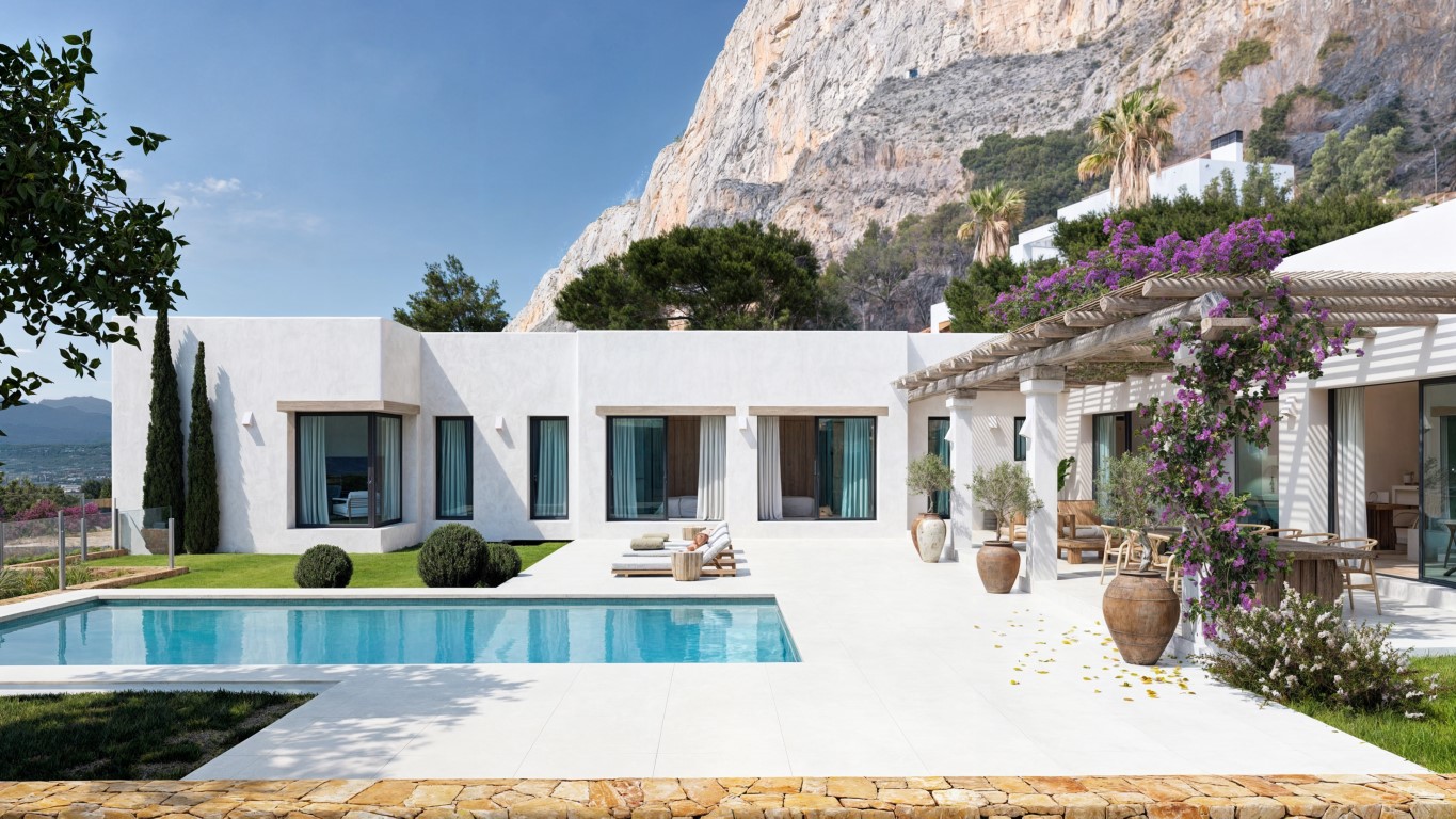 Mediterrane witte villa met rechthoekig zwembad, licht betegeld terras en een houten pergola met bougainville tegen de achtergrond van het imposante Montgó-gebergte.