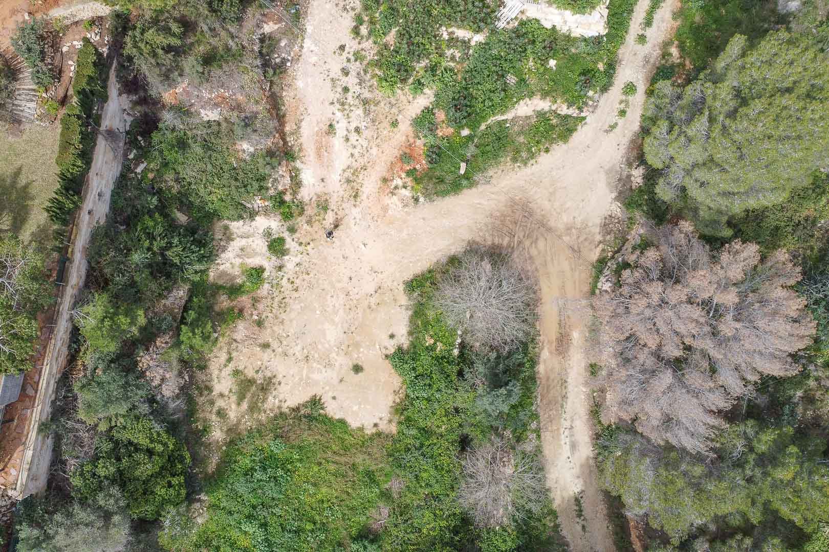 Luchtfoto van het bouwperceel in La Corona, met het natuurlijke terrein en de toegangspaden voorafgaand aan de realisatie van de op maat gemaakte villa.