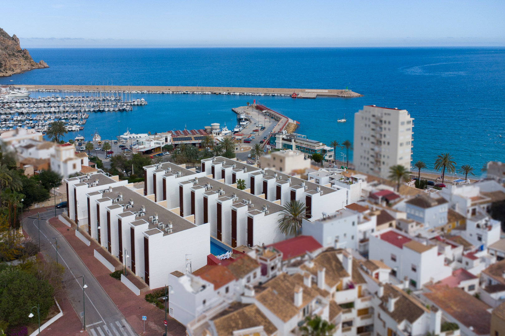 Luchtfoto van de haven van Jávea en moderne wooncomplexen aan de Middellandse Zee, die de uitstekende ligging nabij de kust benadrukt.