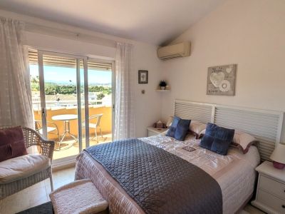 De hoofdslaapkamer heeft een tweepersoonsbed met lattenhoofdbord, airconditioning en directe toegang tot een privéterras met zitje en vergezichten.