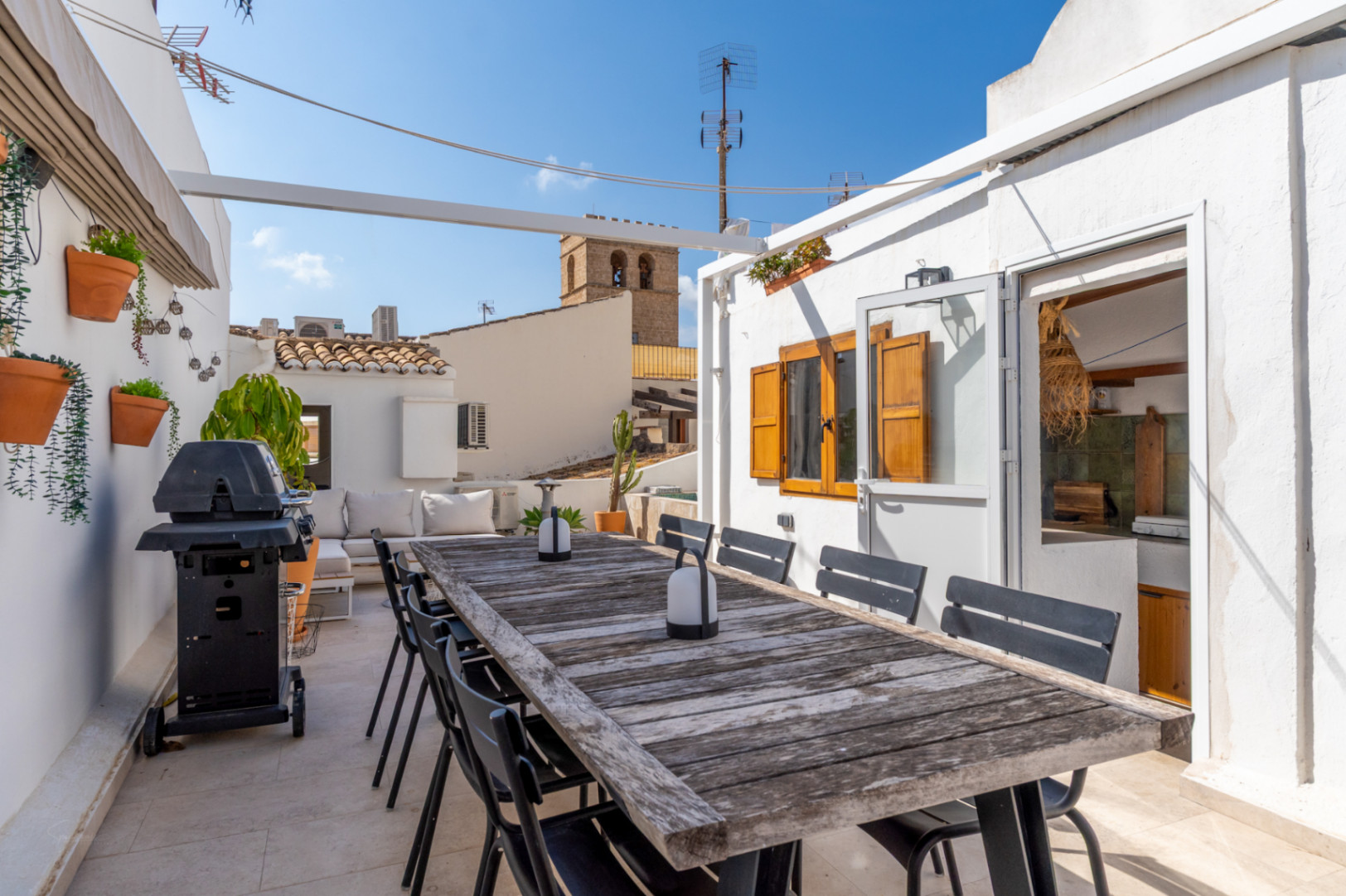 Terras met rustieke houten tafel, BBQ en uitzicht op de oude stad van Jávea.