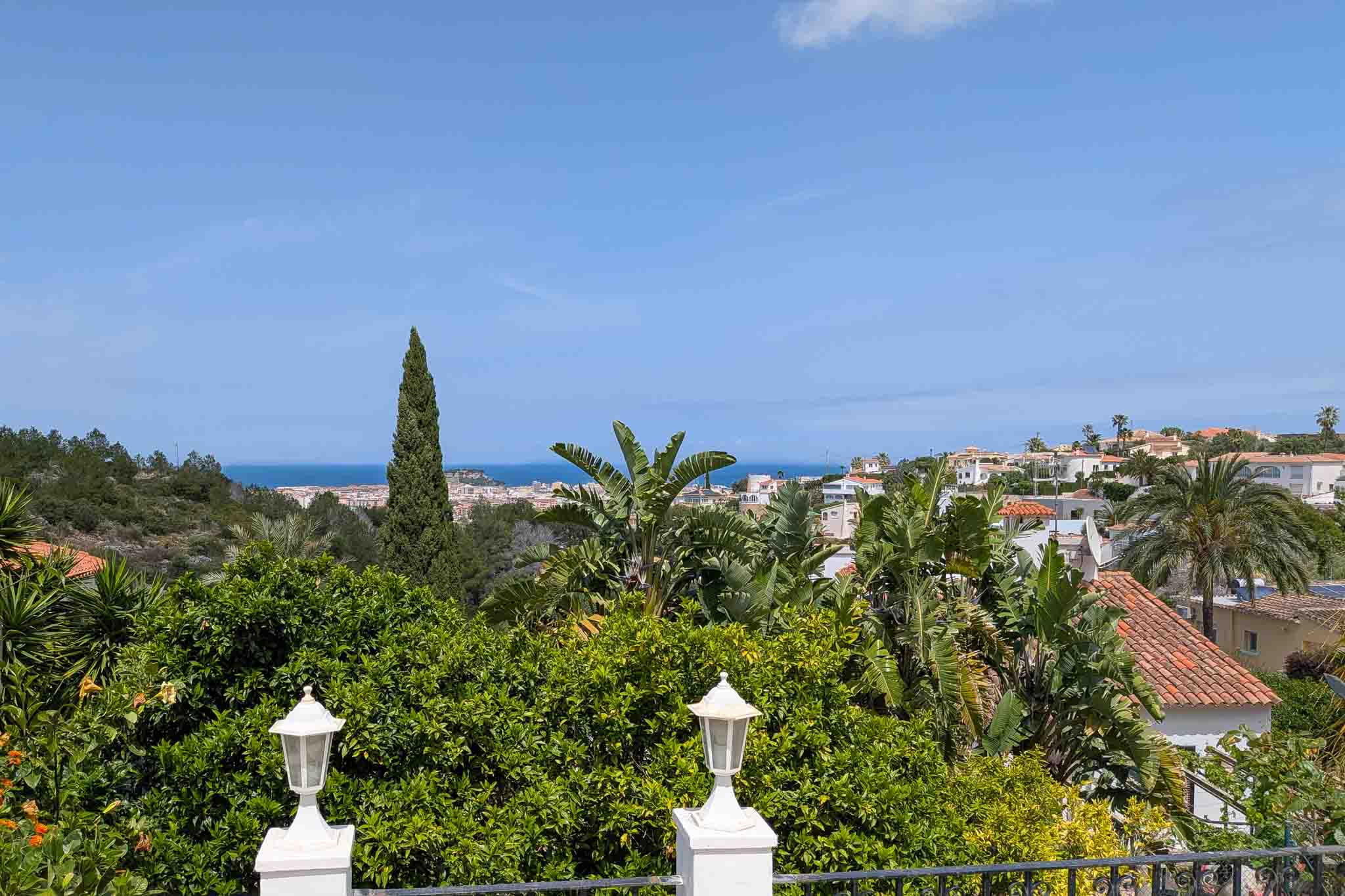 Panoramisch uitzicht op de Middellandse Zee en Dénia vanaf het boventerras, omgeven door mediterrane beplanting en citrusbomen.