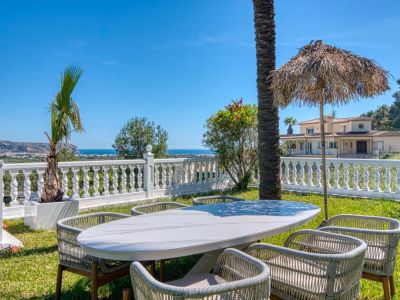 Buiten eetgedeelte met marmeren tafel en uitzicht op de Middellandse Zee vanuit de tuin van de villa.