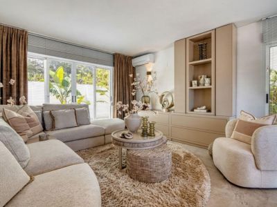 Lichte woonkamer met modulaire bank, rond hoogpolig tapijt en ingebouwde opbergkast.