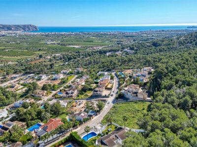 Luchtfoto van de urbanisatie Piver in Jávea, met villa's, zwembaden en mediterrane vegetatie.