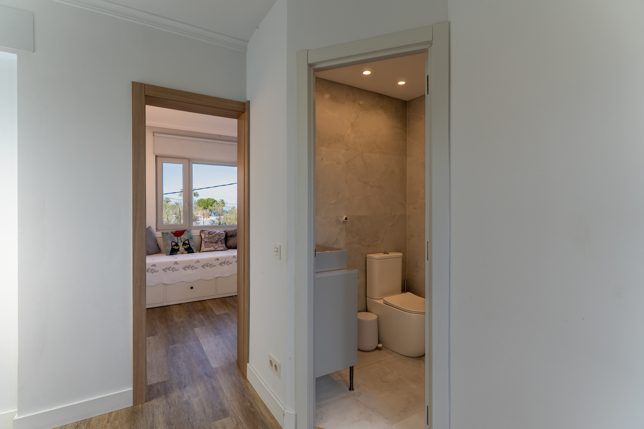 Hal detail met toegang tot marmeren badkamer en slaapkamer met natuurlijk licht.