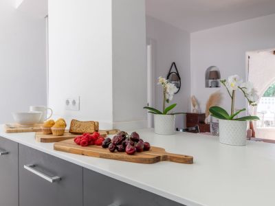 Detail van het aanrecht met fruit en bloemen, met een helder, modern ontwerp.