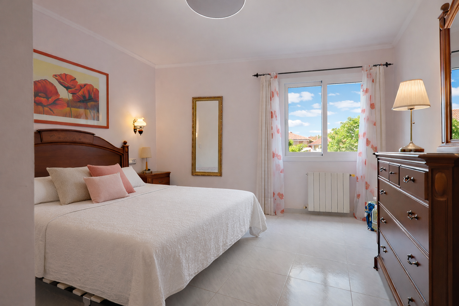 Lichte slaapkamer met houten bed, klassieke commode en uitzicht naar buiten.