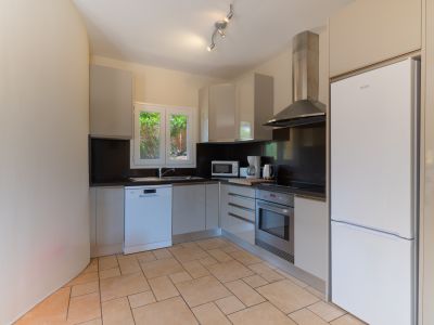 Lichte keuken met donkere werkbladen en moderne roestvrijstalen apparaten.