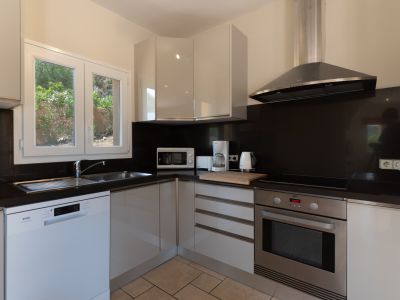 Moderne keuken met zwart aanrechtblad en roestvrijstalen apparaten.
