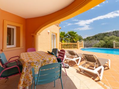 Overdekt terras met eettafel en toegang tot het zwembad in Jávea.
