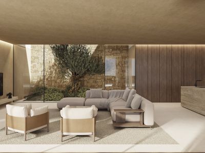 Moderne woonruimte met kamerhoge ramen, uitzicht op stenen muur en olijfboom. Beschikt over een modulaire bank, fauteuils en een stenen eiland met kraan, met lineaire plafondverlichting.