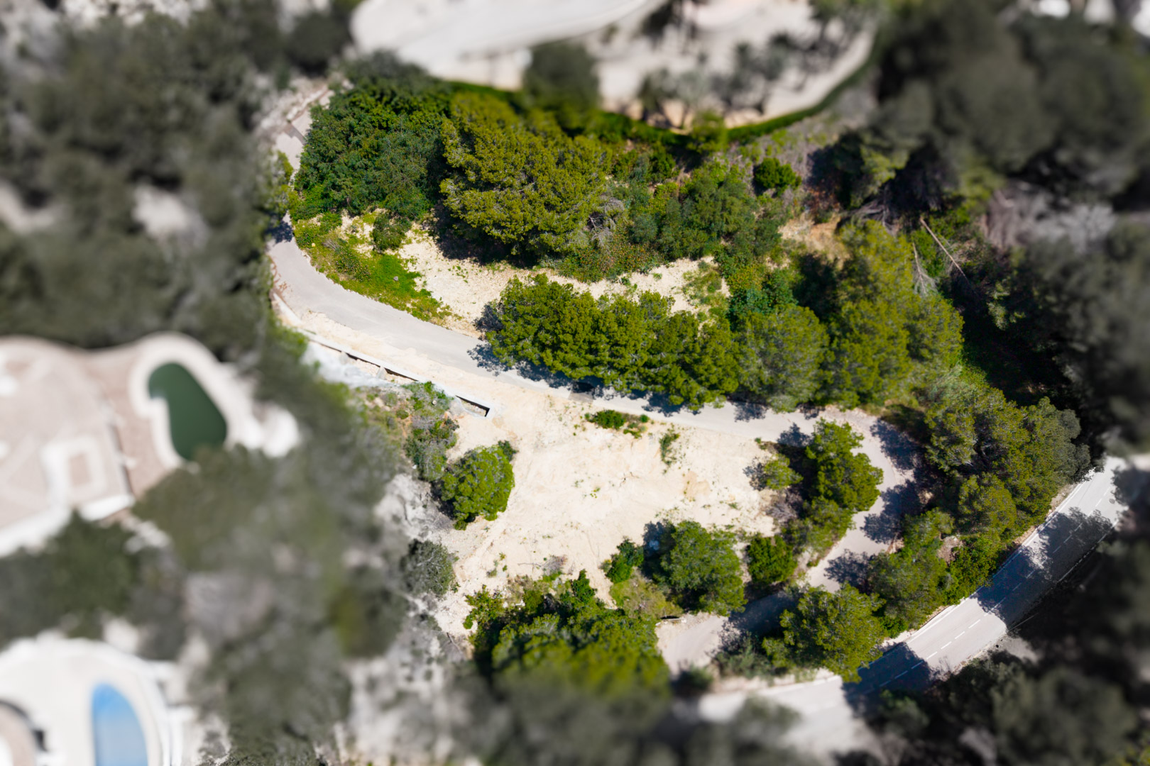 Luchtfoto van een perceel in Mar Azul, Jávea, met onbebouwd land omgeven door groen.