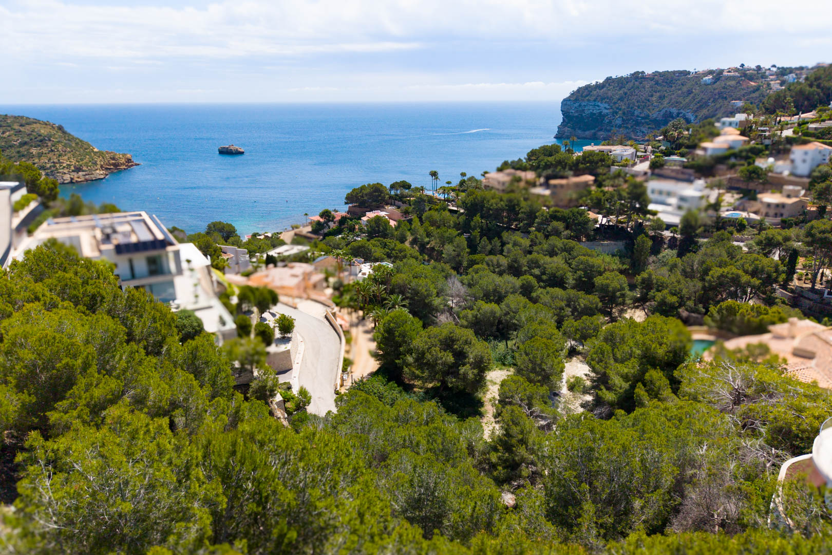 Luchtfoto van het perceel in Mar Azul, Jávea, met uitzicht op de Middellandse Zee en het omliggende groen.