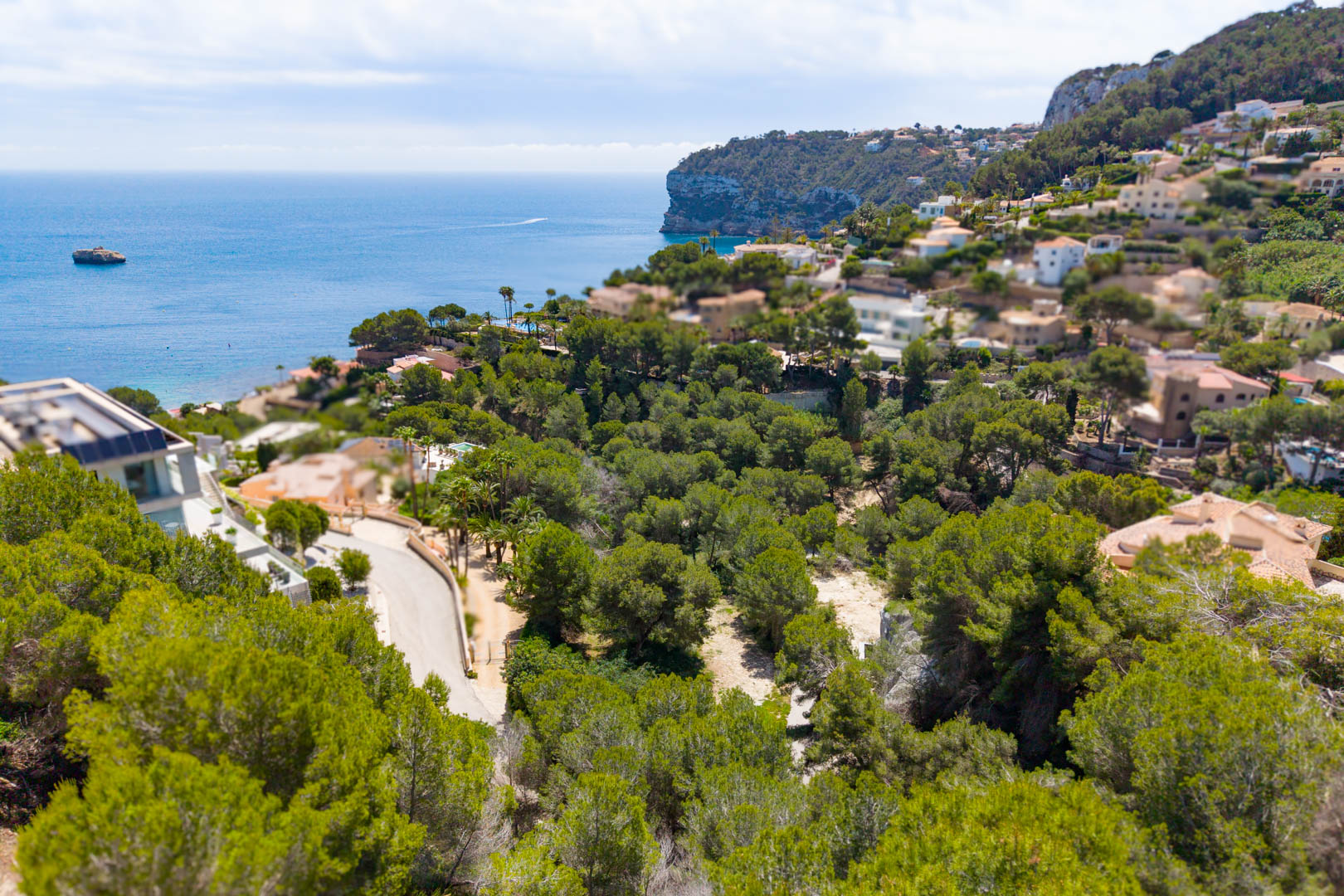Luchtfoto van het perceel in Mar Azul, Jávea, met weelderig groen en uitzicht op zee.