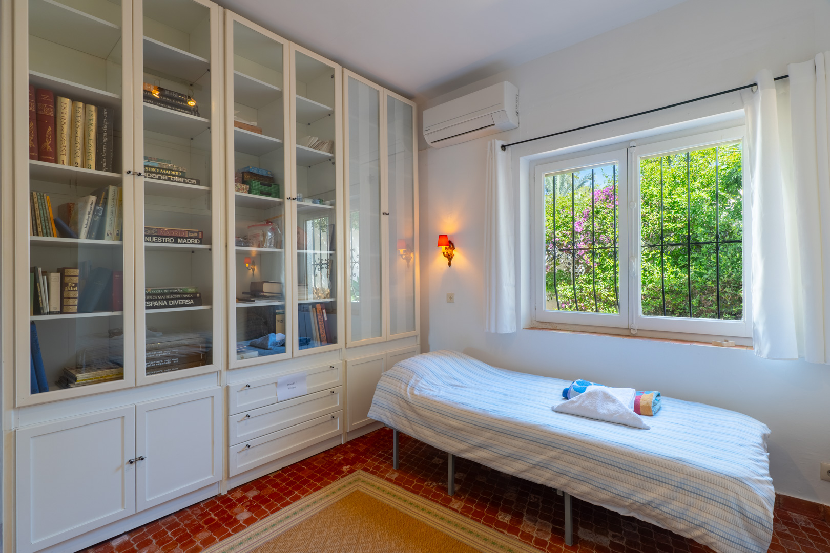 Lichte slaapkamer met ingebouwde kasten en uitzicht op de tuin.
