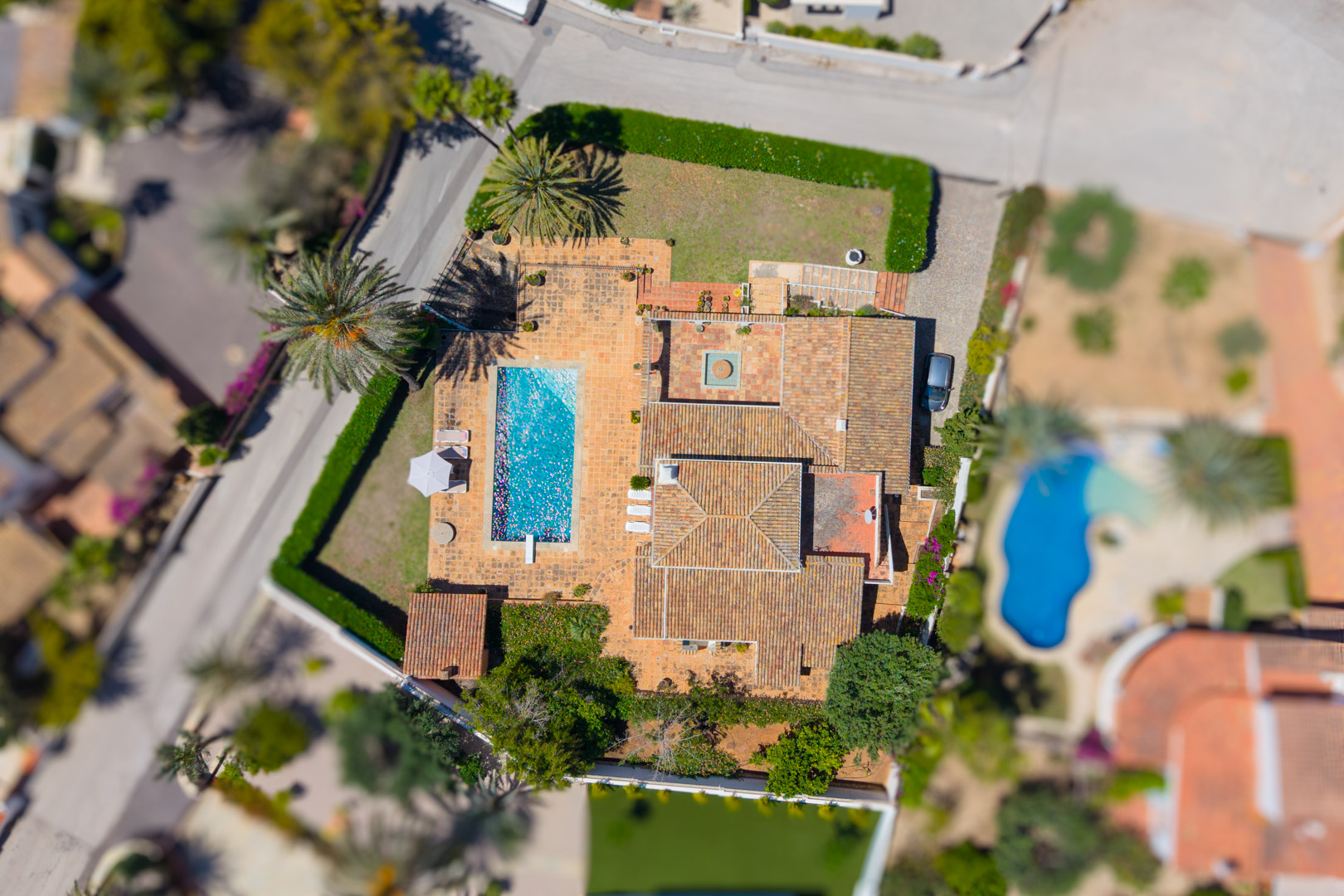 Luchtfoto van de villa met rechthoekig zwembad en rood pannendak.