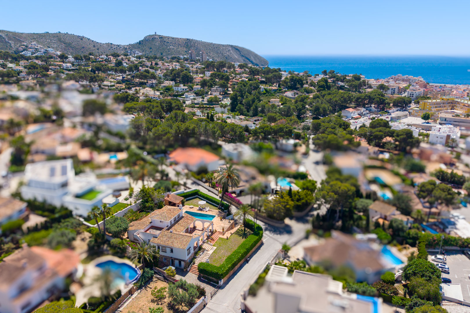 Luchtfoto van de villa met zwembad en stenen bogen, omgeven door mediterrane begroeiing.