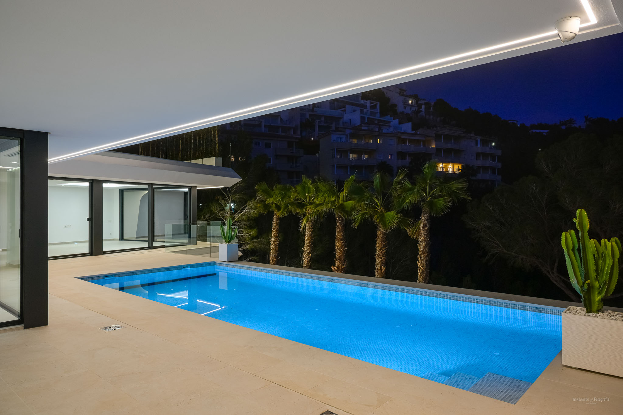 Moderne infinity pool met ruim zonneterras, met panoramisch uitzicht op de Middellandse Zee. De buitenruimte toont eigentijds design en weelderige, onderhoudsarme beplanting.