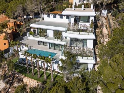 Luchtfoto van een moderne, meerlaagse witte villa, genesteld op een groene heuvel. Voorzien van een groot privézwembad, ruime terrassen met glazen balustrades en palmbomen, omgeven door mediterraan bos.