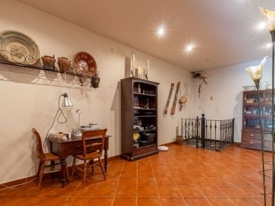Functionele studeerhoek met houten bureau, terracotta vloertegels en traditionele wanddecoratie. De ruimte omvat een boekenkast en een elegant smeedijzeren balustrade.