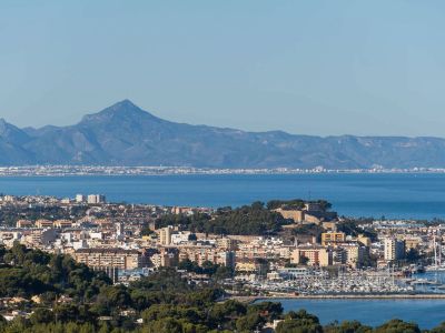 Panoramisch uitzicht op Dénia, met het historische kasteel, de levendige jachthaven en het stedelijke landschap voor de Middellandse Zee en het Montgó-gebergte.
