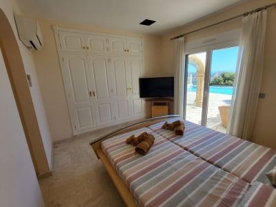 Slaapkamer met twee eenpersoonsbedden, inbouwkast en directe toegang tot het zwembad. Voorzien van tv en airconditioning, met uitzicht naar buiten.