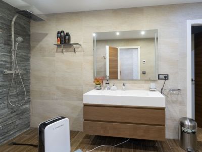 Moderne badkamer met regendouche en leisteen-accentmuur, zwevend houten wastafelmeubel en geïntegreerde wasbak. Tegels met houtlook op de vloer.